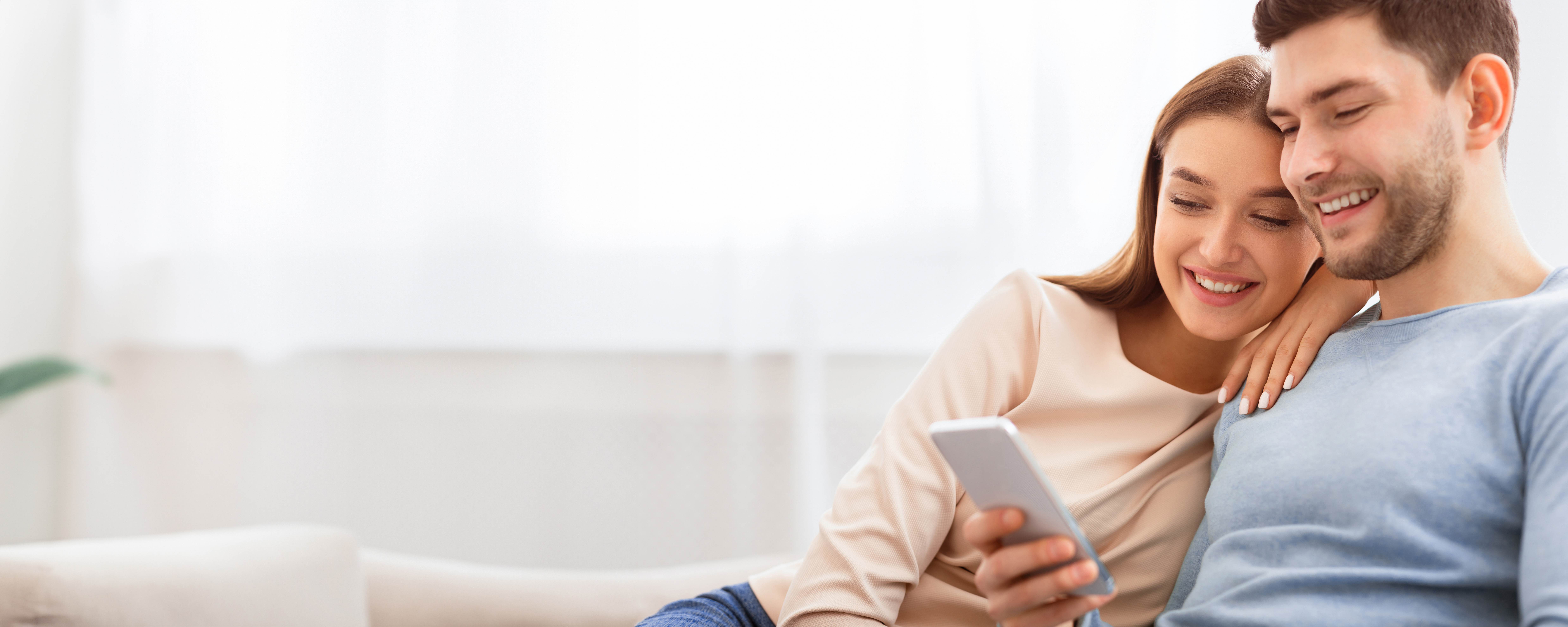 Couple checking their phone together at home